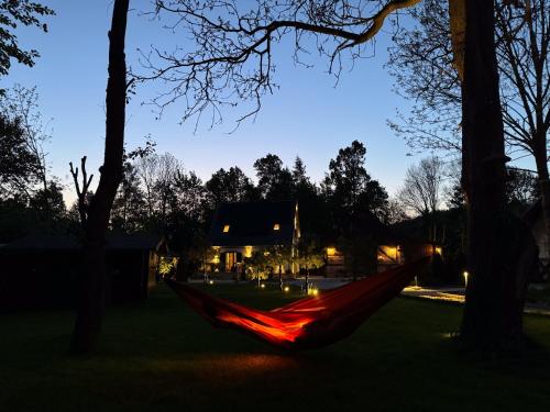 a hammock in the yard of a house at night at Domek pod Świerkami & Jacuzzi in Jelenia Góra
