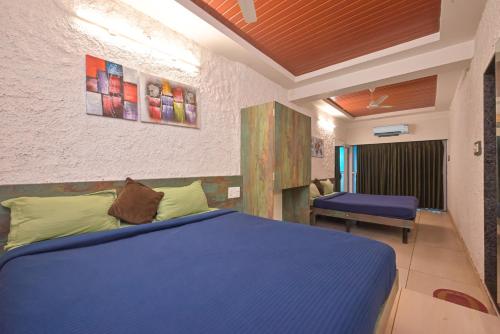 a bedroom with a blue bed and a chair at Bricstone House 11BHK By Stayscape Villas in Lonavala