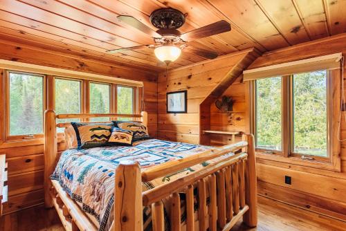 een slaapkamer met een bed in een blokhut bij Grayling Gem Royal Stag Serene 6BDR Lodge 5605 in Grayling