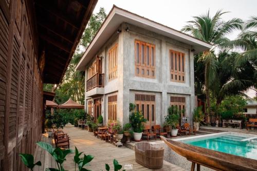 a resort with a swimming pool and a building at House Of Passion Amphawa in Amphawa