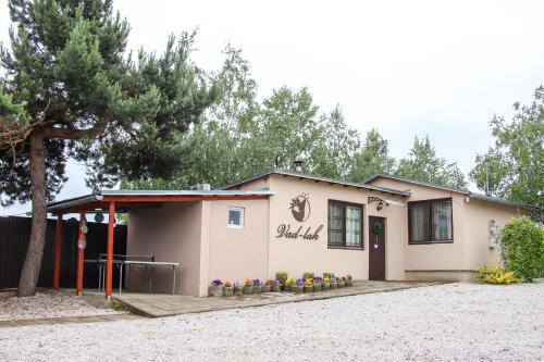 a building with a tree in front of it at Vad-lak Vendégház in Aggtelek