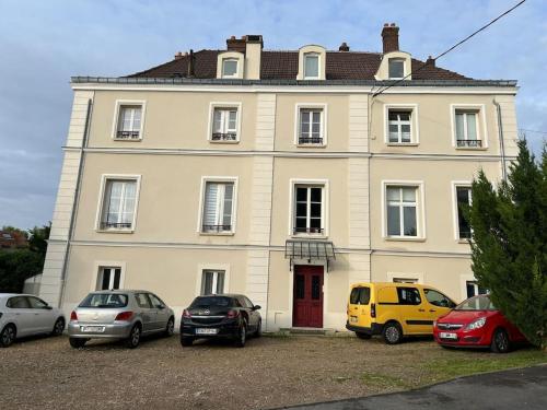 a large white house with cars parked in front of it at Charmant cocon, Lagny sur marne, parking, wifi, proche Disney RER in Lagny