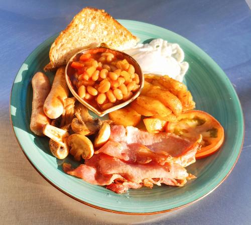 a green plate of food with beans and bread at Crocodile Pools Resort in Gaborone