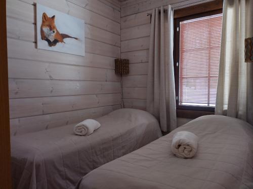 two twin beds in a room with a window at Ruka Star in Ruka