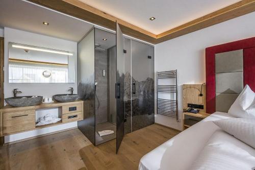 a large bathroom with two sinks and a shower at Wellnessresort Seiwald **** Superior in Going
