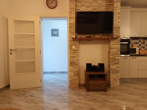 a living room with a television on a brick wall at Villa Katarina in Tivat