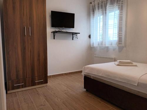 a bedroom with a bed and a tv on a wall at Villa Katarina in Tivat
