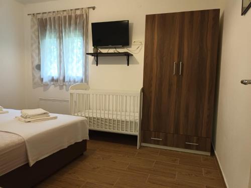 a bedroom with a bed and a large wooden cabinet at Villa Katarina in Tivat