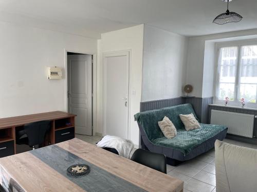 a living room with a couch and a table at Appartement RDC Dinan in Dinan