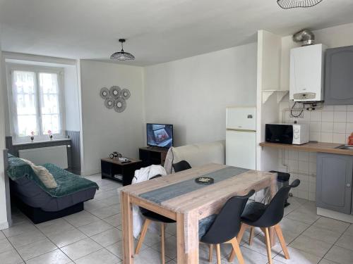 une cuisine avec une table et des chaises dans une pièce dans l'établissement Appartement RDC Dinan, à Dinan