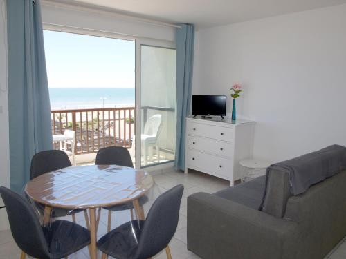 un salon avec un canapé et une table avec des chaises dans l'établissement Beau Studio à Saint-Jean-de-Monts, Face à la Mer - FR-1-323-425, à Saint-Jean-de-Monts