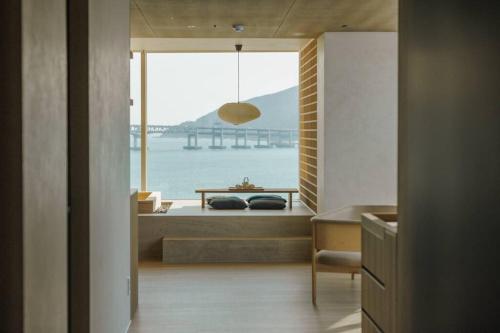 a room with a bed with a view of the water at ONUJI stay in Busan