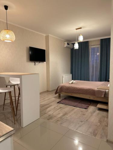1 dormitorio con cama, mesa y TV en Orange Batumi Travel, en Batumi