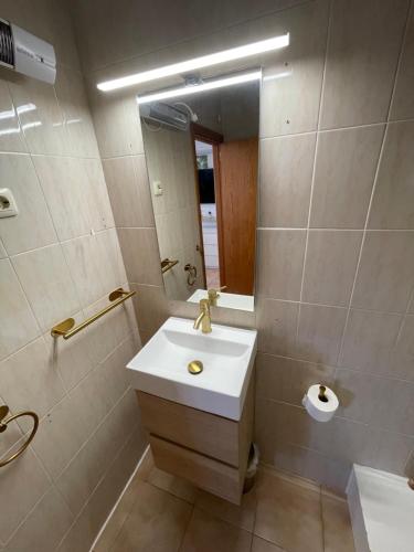 a bathroom with a sink and a mirror at Studio Cielo- pool, wi-fi & more in Los Urrutias