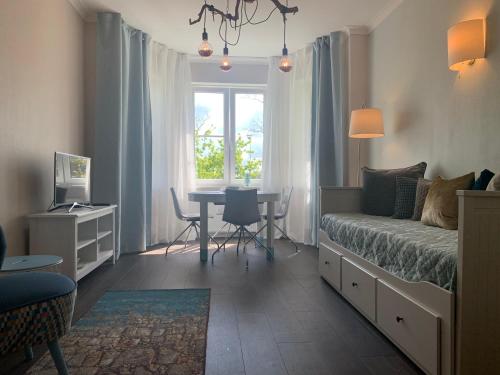a bedroom with a bed and a table and a window at AquaGate Jurmala in Jūrmala