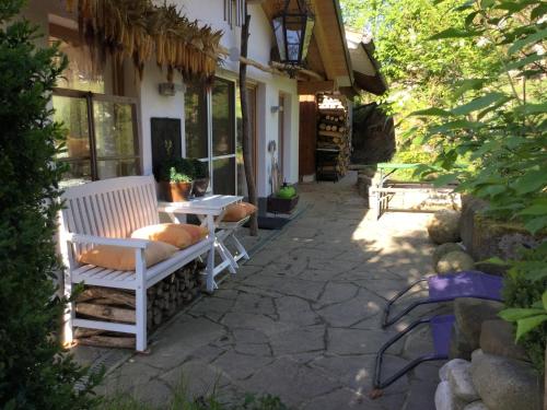 a patio with a white bench and a table at Studioatelier am Naturschutzgebiet in Dietramszell