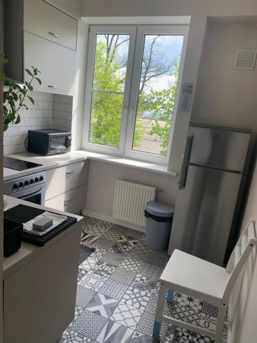 a small kitchen with a refrigerator and a window at AquaGate Jurmala in Jūrmala