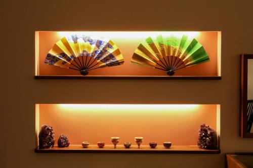 a shelf with three colorful umbrellas on a wall at ROMANSTAY in Takayama