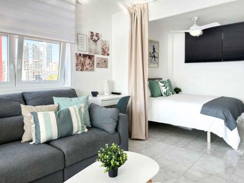 ein Wohnzimmer mit Sofa und Bett in der Unterkunft BALCÓN AL MEDITERRÁNEO Y SKYLINE DE BENIDORM in Benidorm