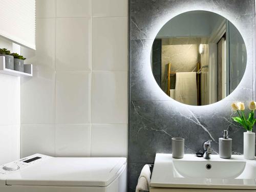 ein Badezimmer mit einem weißen Waschbecken und einem Spiegel in der Unterkunft BALCÓN AL MEDITERRÁNEO Y SKYLINE DE BENIDORM in Benidorm