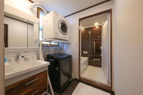 bagno con lavandino, specchio e doccia di ROMANSTAY a Takayama