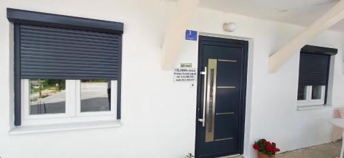 dom z czarnymi drzwiami i oknami w obiekcie Prenoćište Most Šljuka d o o w mieście Tomislavgrad