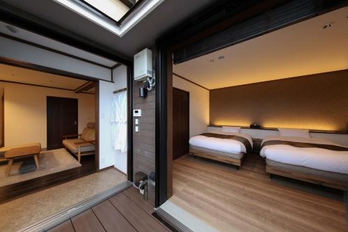 a bedroom with two beds and a living room at ROMANSTAY in Takayama