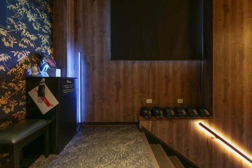 a room with a wall with a television and a bench at ROMANSTAY in Takayama