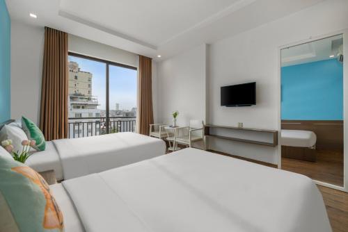 um quarto de hotel com duas camas e uma televisão de ecrã plano em Beach Hotel by RAON - STAY 24H em Da Nang