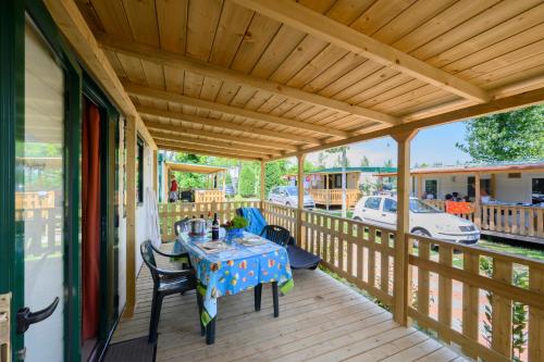una terrazza in legno con tavolo e sedie. di Ca' Berton Village a Cavallino-Treporti