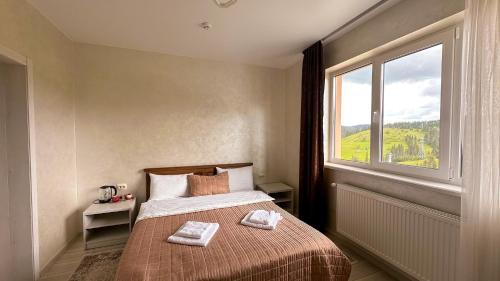 a bedroom with a bed with two towels on it at Шепіт Лісу in Bukovel