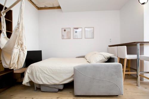 a bedroom with a bed and a chair at Montsejour - T2 climatisé avec filet et fauteuil suspendu in Tarbes