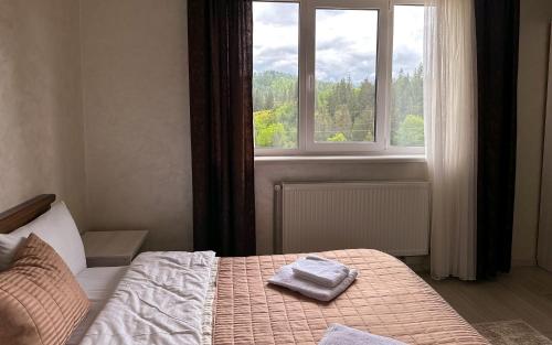 a bedroom with a bed with two towels on it at Шепіт Лісу in Bukovel