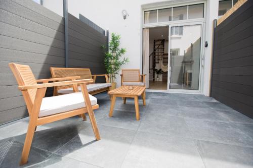 two chairs and a table on a patio at Montsejour - T2 climatisé avec filet et fauteuil suspendu in Tarbes