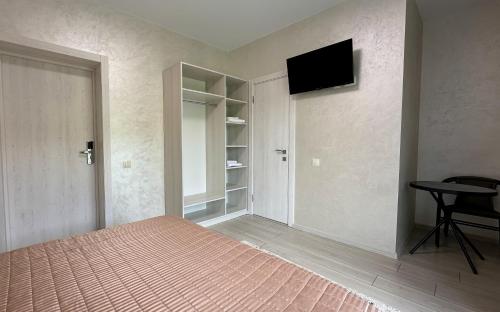 a bedroom with a bed and a flat screen tv at Шепіт Лісу in Bukovel
