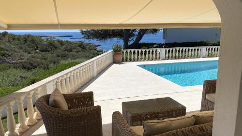 a balcony with chairs and a swimming pool at Villa HERMITAGE in Binissafuller