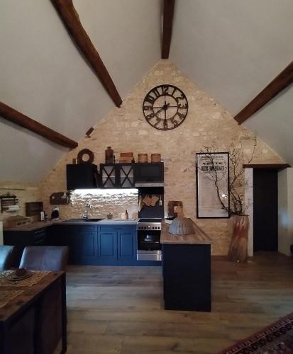 une grande cuisine avec une grande horloge murale dans l'établissement La lande sèche, à Lainsecq