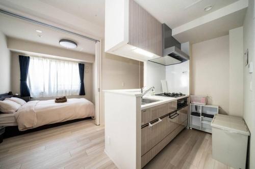 a kitchen with a sink and a bed in a room at Morganite in Sapporo
