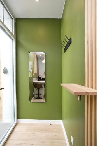 une pièce verte avec un miroir et un bureau dans l'établissement Montsejour - Appartement exceptionnel avec SPA, à Tarbes