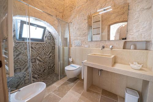 uma casa de banho com um lavatório, um WC e um chuveiro em Bed and Breakfast Trulli San Leonardo em Alberobello