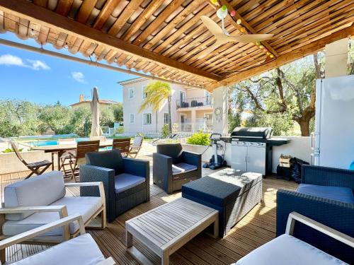 Villa SYAGRUS - Easy Home Booking في نيس: فناء مع كراسي وطاولات وشواية