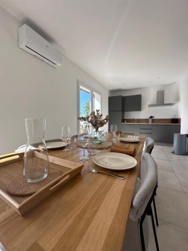 une salle à manger avec une table en bois et des verres à vin dans l'établissement Bergerie avec spa vue montagne, à San-Nicolao