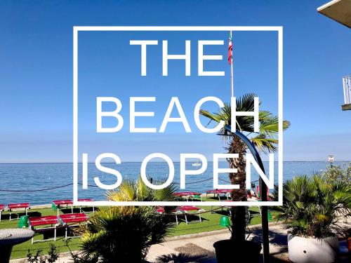 un grande cartello che legge la spiaggia è aperto di Hotel Riviera & Maximilian's a Trieste