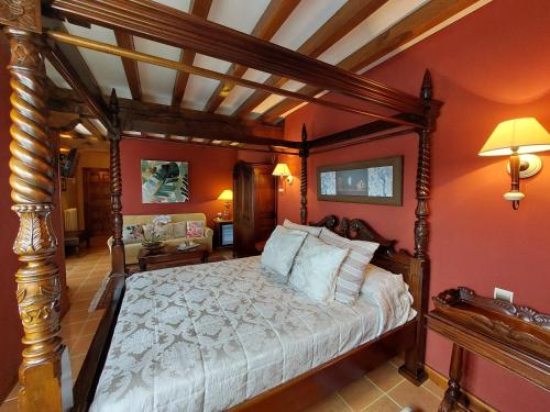 sypialnia z łóżkiem z baldachimem i czerwonymi ścianami w obiekcie Señorio De Altamira - Adults Only w mieście Santillana del Mar