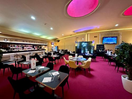 ein Restaurant mit Tischen und Stühlen und eine Bar in der Unterkunft Hotel du Pasino in Saint-Amand-les-Eaux