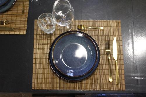 a blue plate and two glasses on a bamboo placemat at Pub house in Lucca