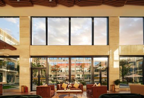 a lobby with large windows and couches in a building at DongHu Resort Hotel in Sihanoukville