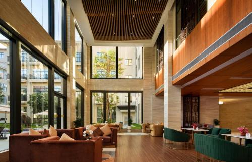 a lobby with couches and tables and windows at DongHu Resort Hotel in Sihanoukville