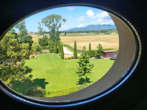 a round window with a view of a field at Appartamento in Villa Aulla in Pontedera