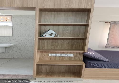 a bedroom with a book shelf next to a bed at Wandr Centauri - Whitefield , Bangalore in Bangalore